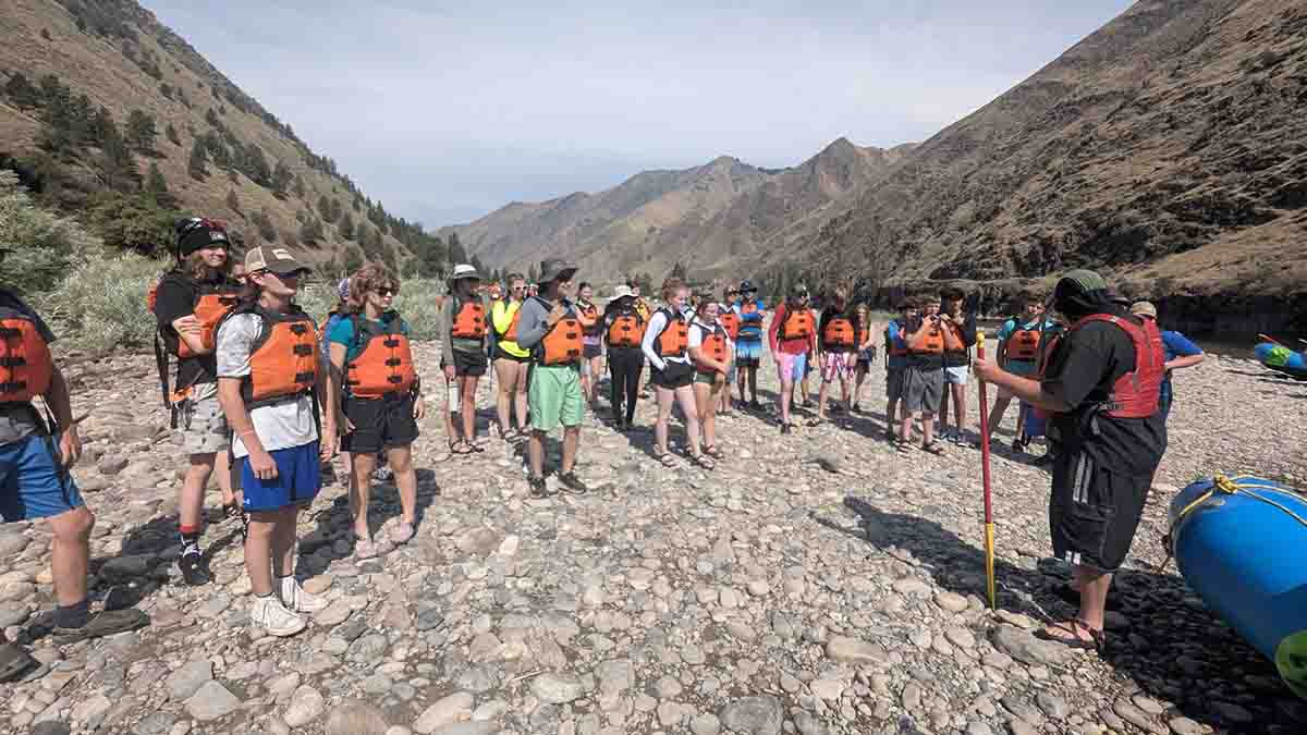A group wearing life jackets before going rafting.