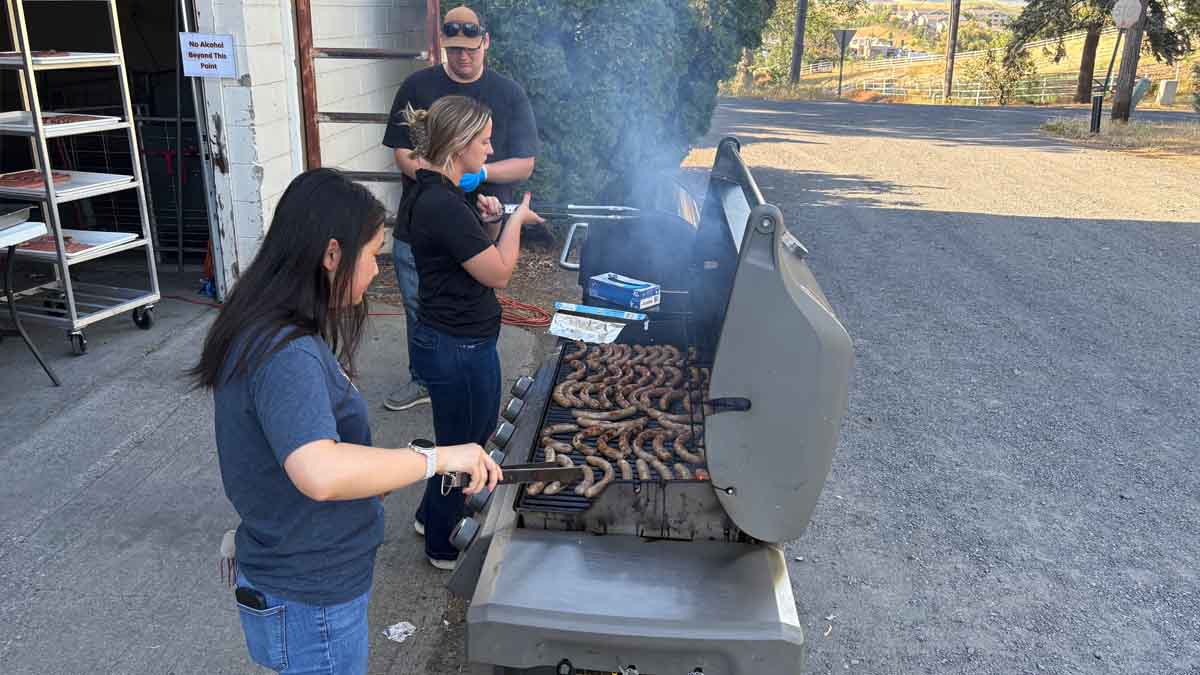 Barbecuing sausages on a grill outside.