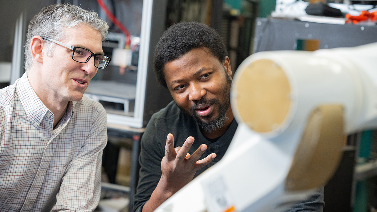 Faculty and student discuss robotic printer.